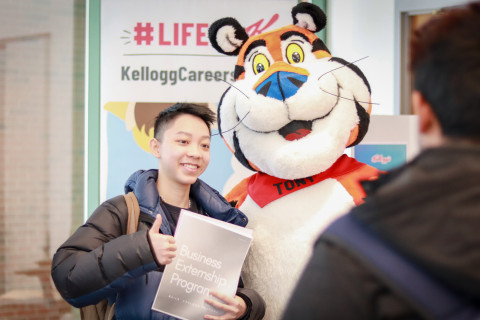 A student is getting a photo with Tony the Tiger, from Kellogg's at a SPuRs-related event.
