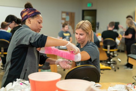 WMU physician assistant students practice applying and removing casts with instructors, staff and other students in the College of Health and Human Services.
