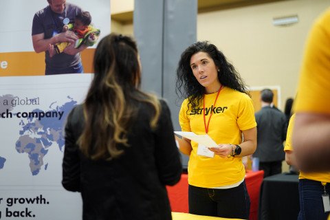 Job fair, student talking with a Stryker rep.