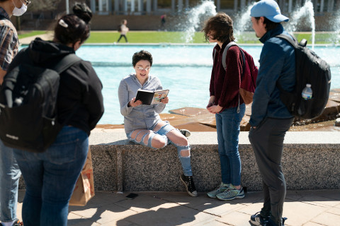 Students listening to a student, at the fountains.