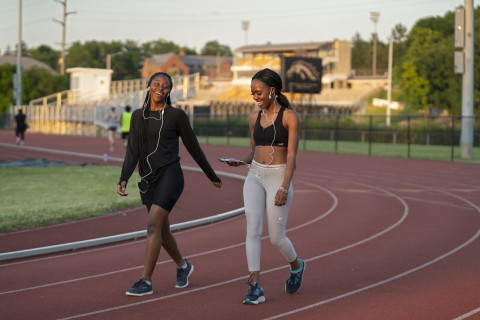 Two women walking on the track.