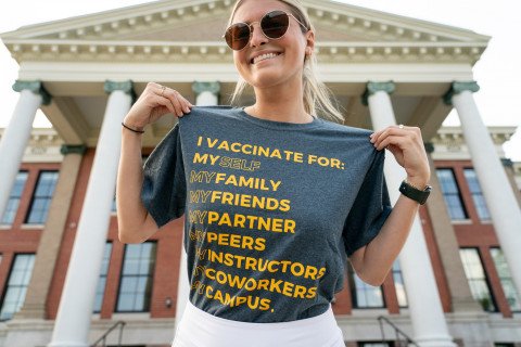 A woman wearing a shirt that says, "I vaccinate for myself, my family, my friends, my partner, my peers, my instructors, my co-workers and my campus.