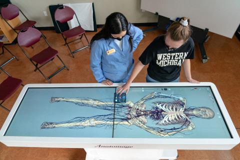 A student and instructor looking at the Anatomage table.