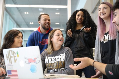 A group of students on a laptop.