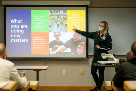 Alumni presenter pointing to whiteboard