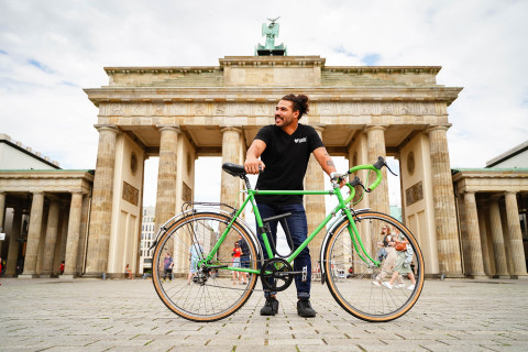 Alumnus Matt Lassiter on a bike at the Brandenburg Gate in Berlin, Germany.