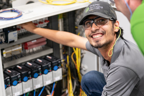 Student smiling while working on equipment