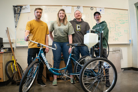 Four students standing with modified bike