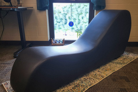 A recliner yoga stretch station in front of a window