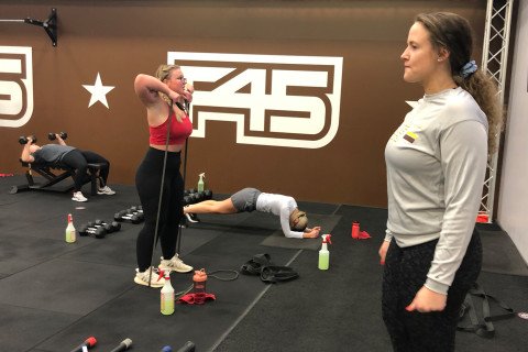 F45 instructor with participant in class