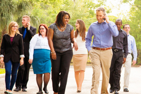 Diverse group of people dressed in business casual clothes walking outside