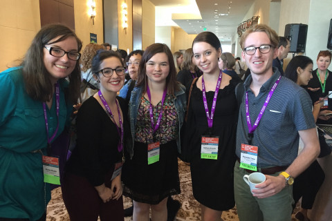 5 students together wearing nametags at a conference.