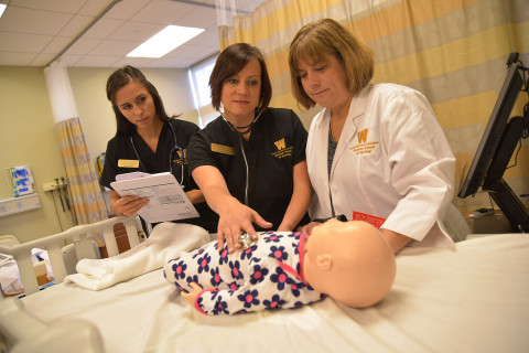 Nursing students and instructor with SIM baby