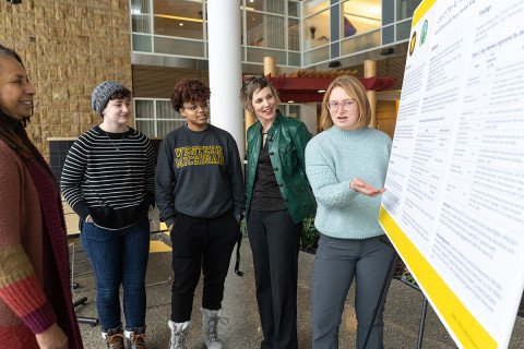 students and faculty presenting posters in the CHHS atrium