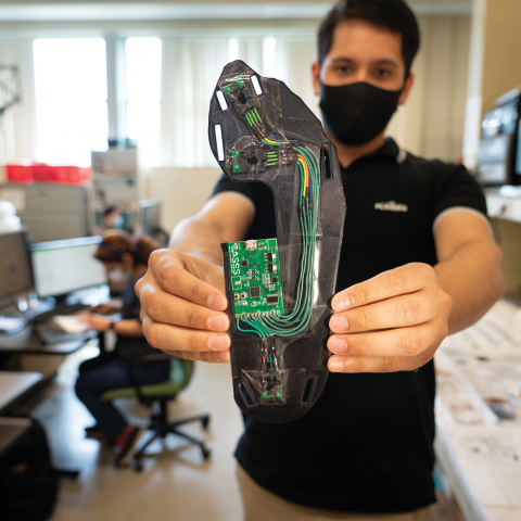 A student holds an insole equipped with sensor technology.