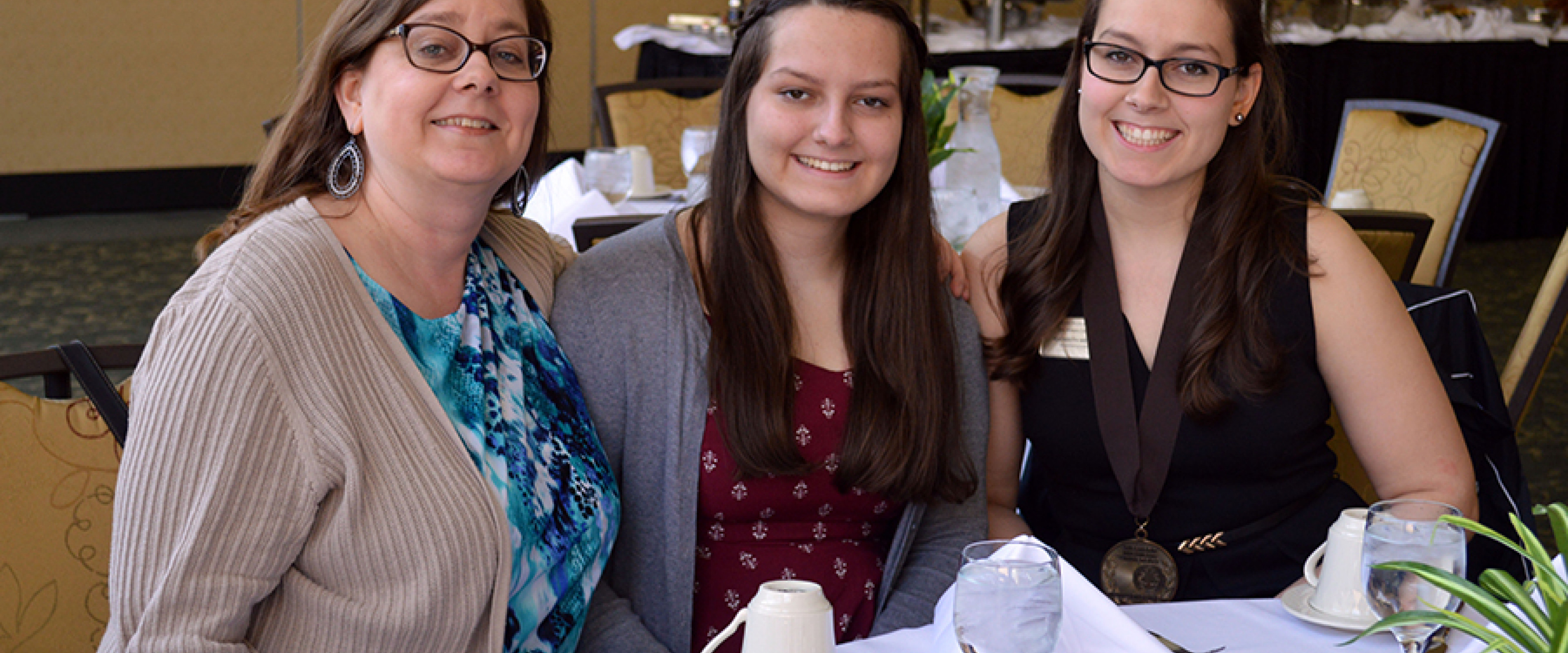 Three women seated at a table attending the annual Medallion brunch.