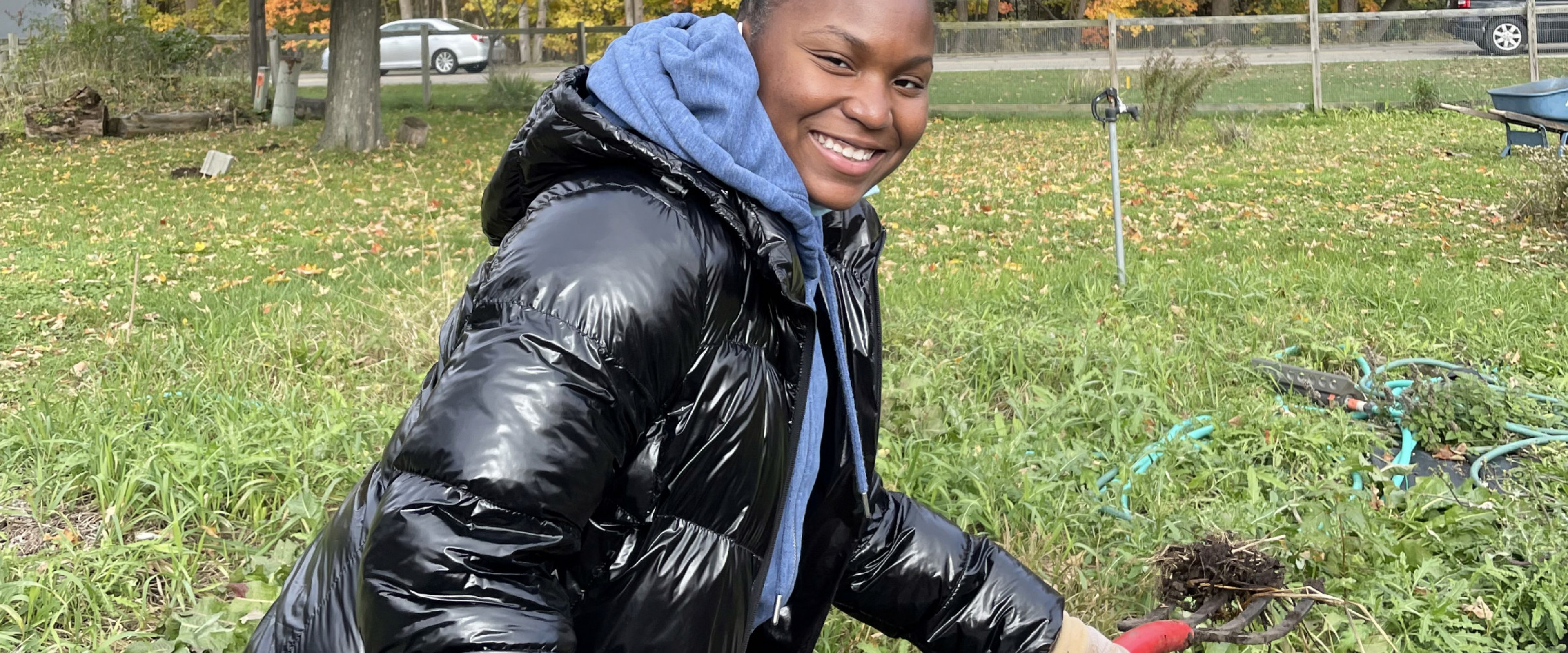 An honors student volunteers in the garden at Gibbs House.