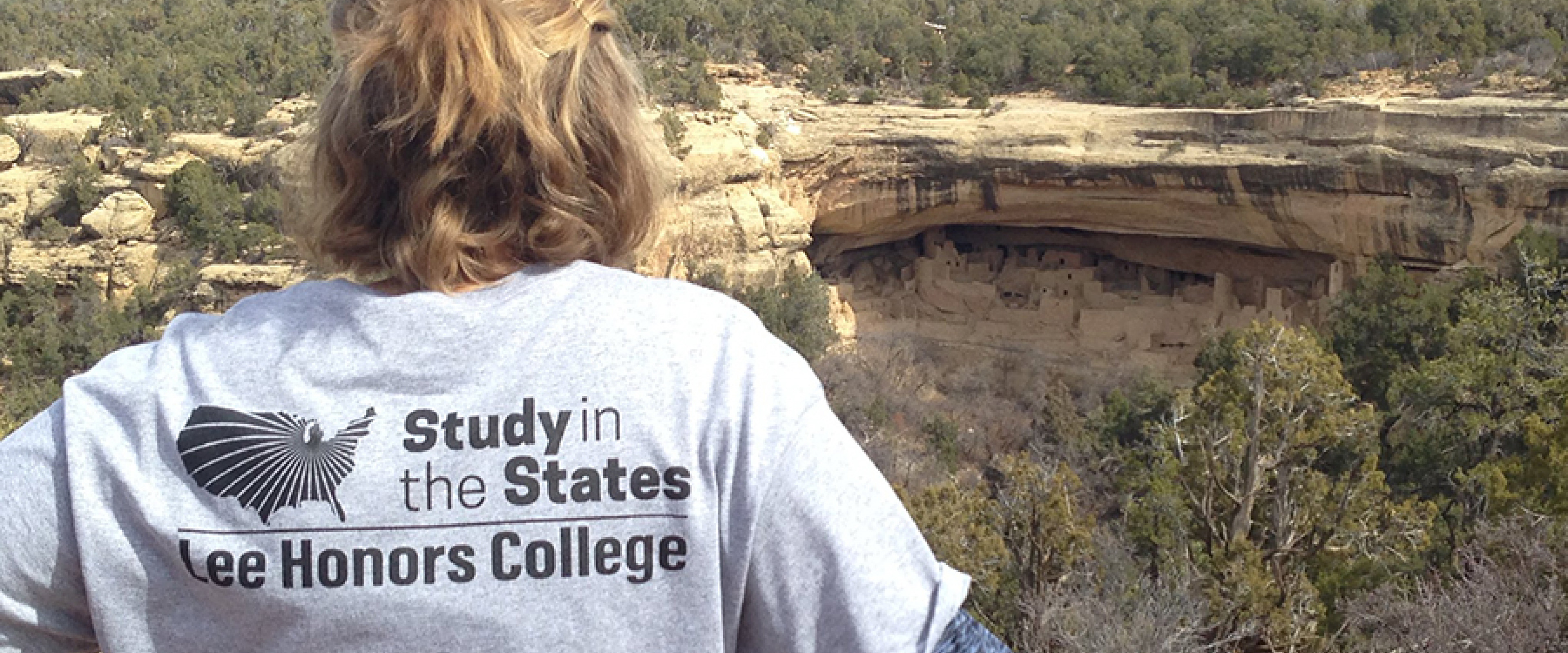 A student in a Study in the States t-shirt looks out over a canyon.