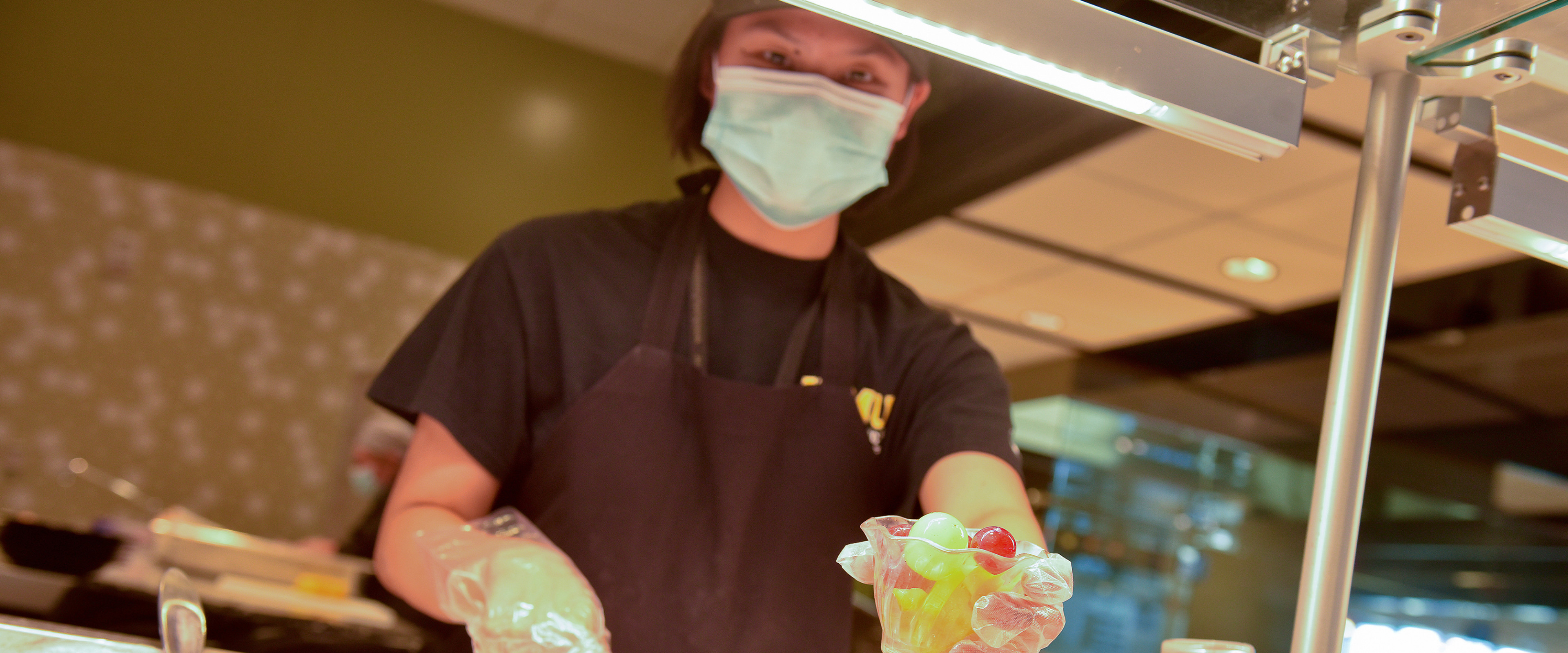 Student worker serving fruit cups