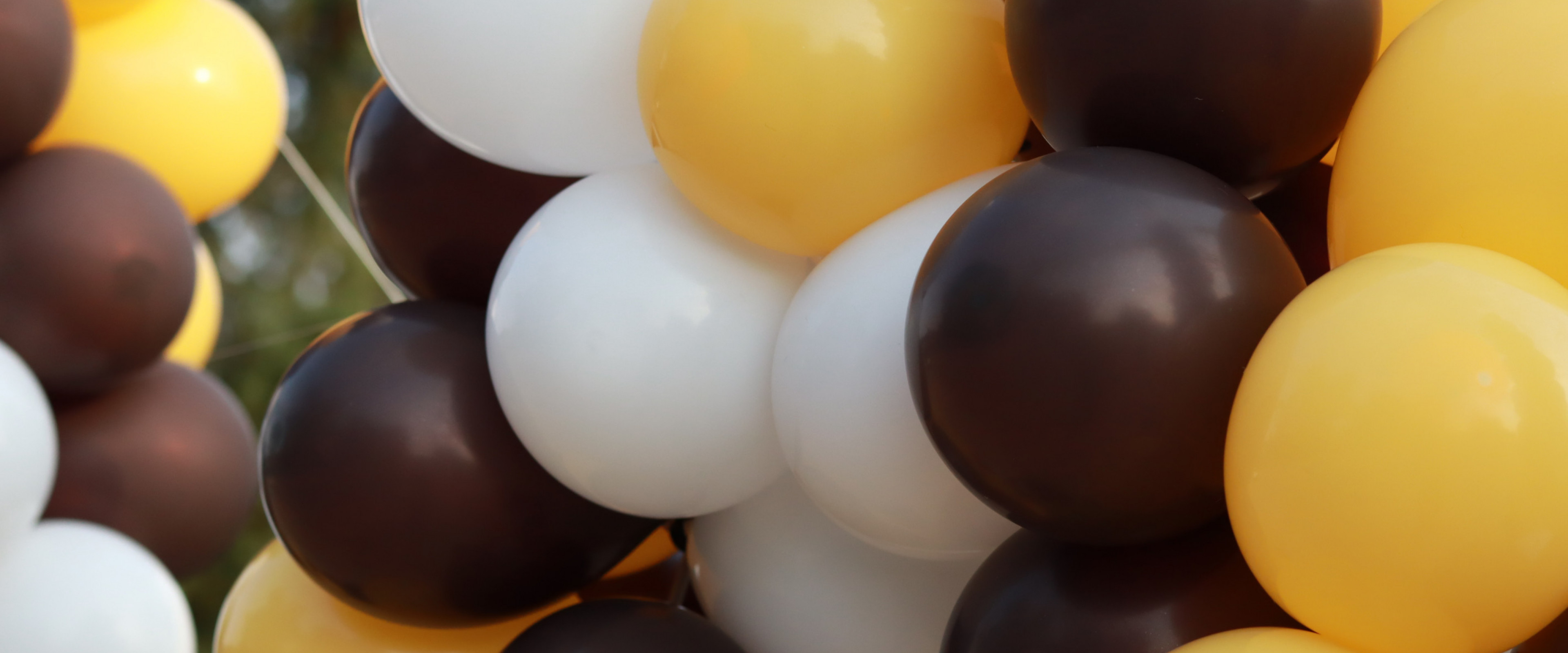 Gold, white and brown balloons in the shape of the letter, W.