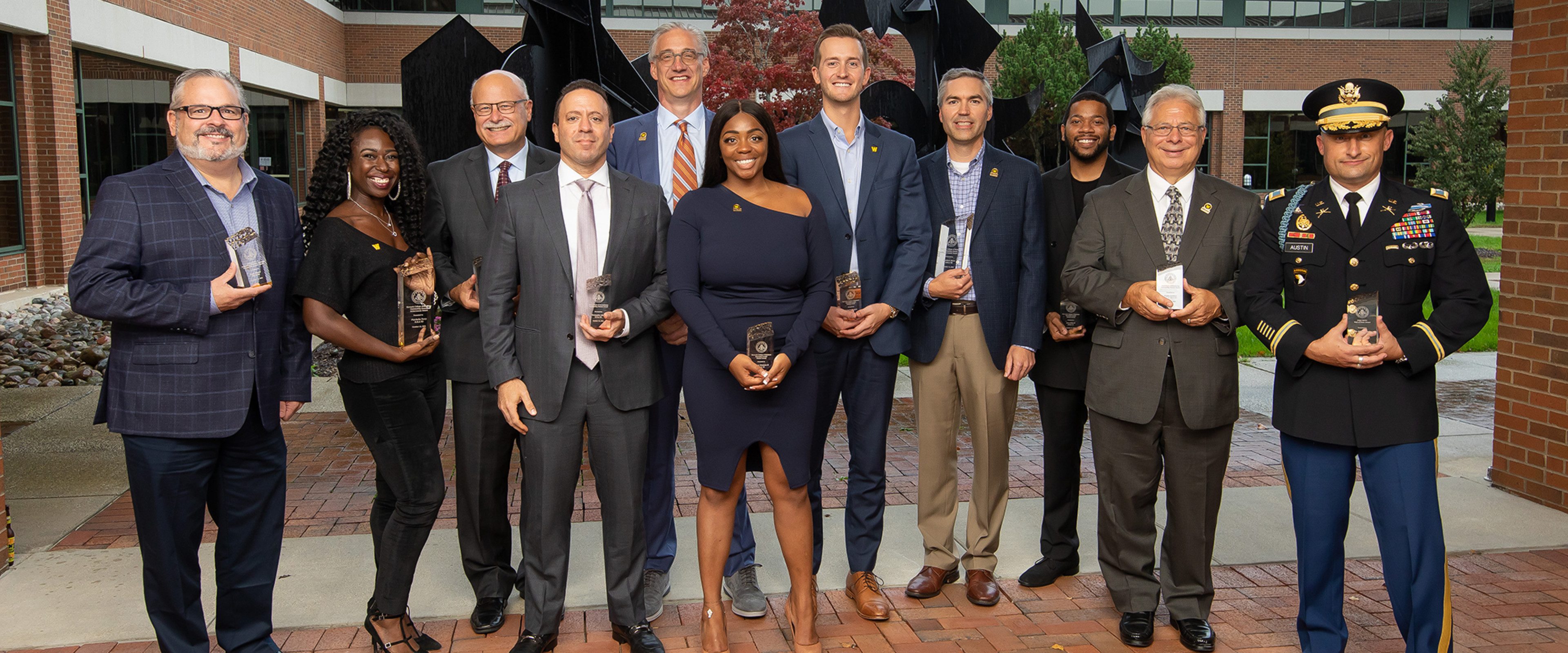 11 WMU Haworth alumni pose with their awards, outside of the Haworth College of Business