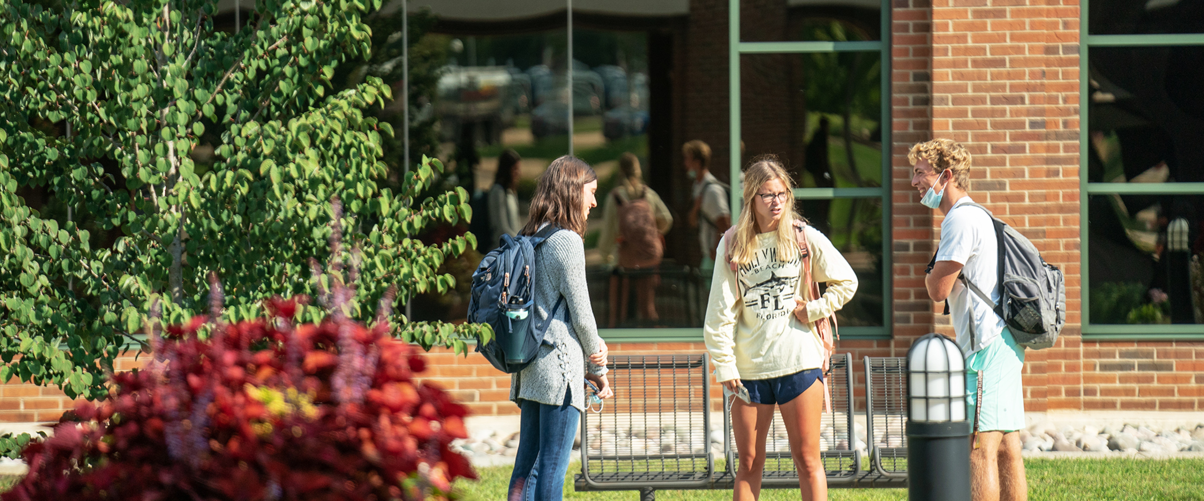 Three students are having a conversation outside of the Haworth College of Business.