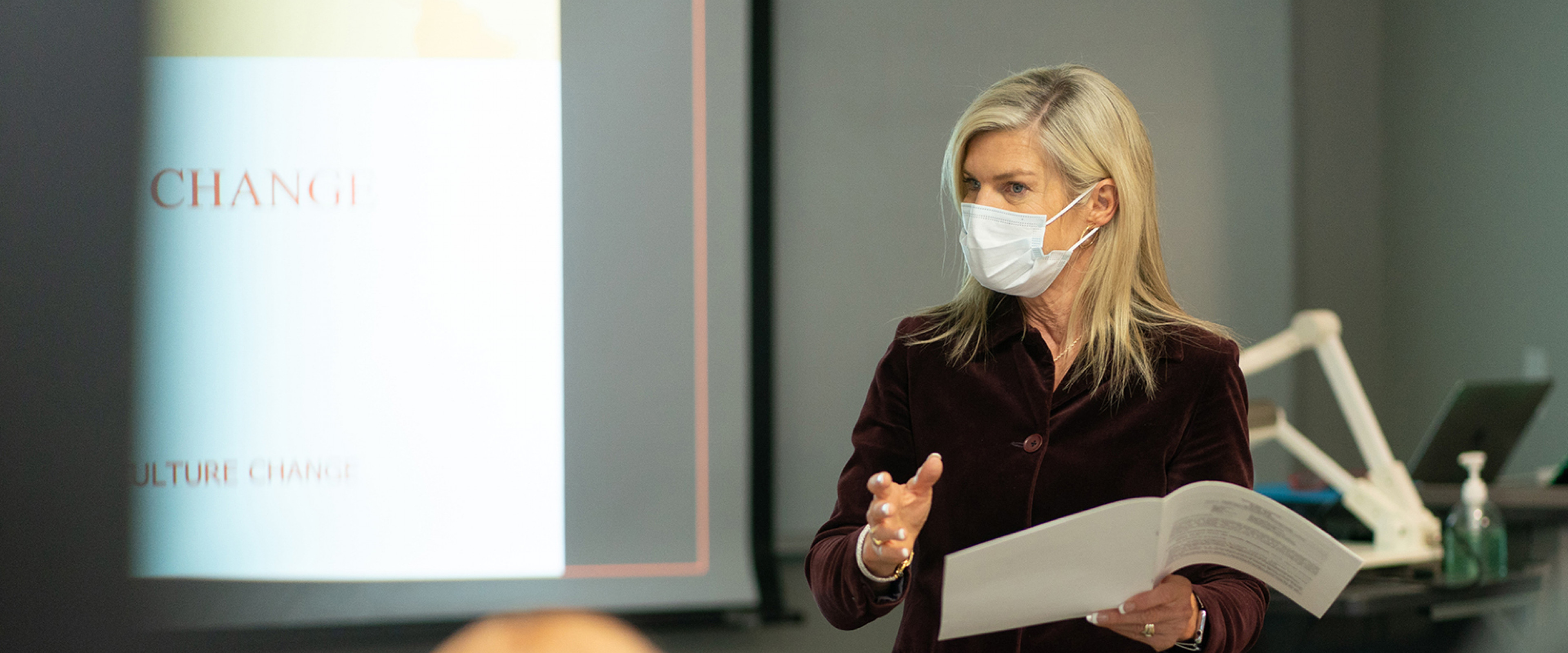 Jennifer Palthe, wearing a mask, teaches an MBA class.