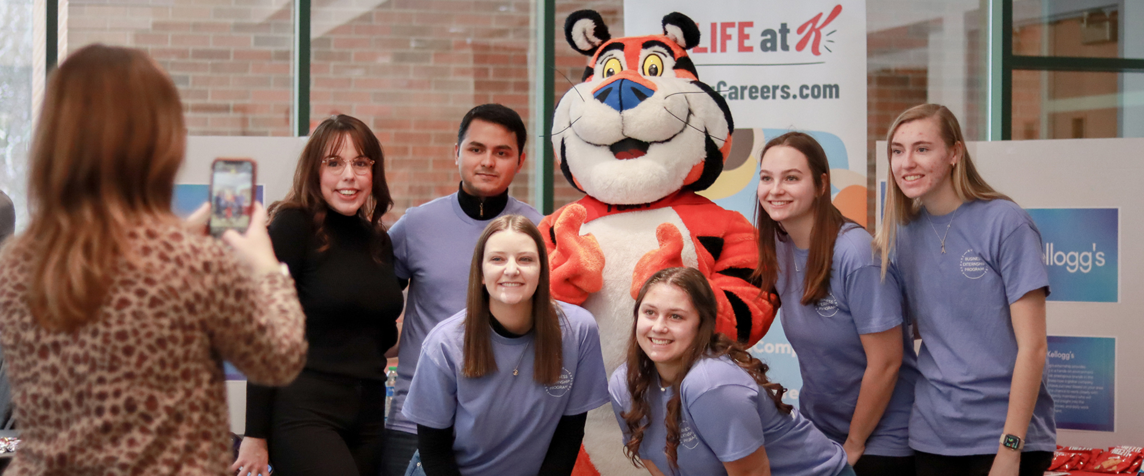 The Business Externship Program students are grabbing a photo with Kellogg's mascot, Tony the Tiger.