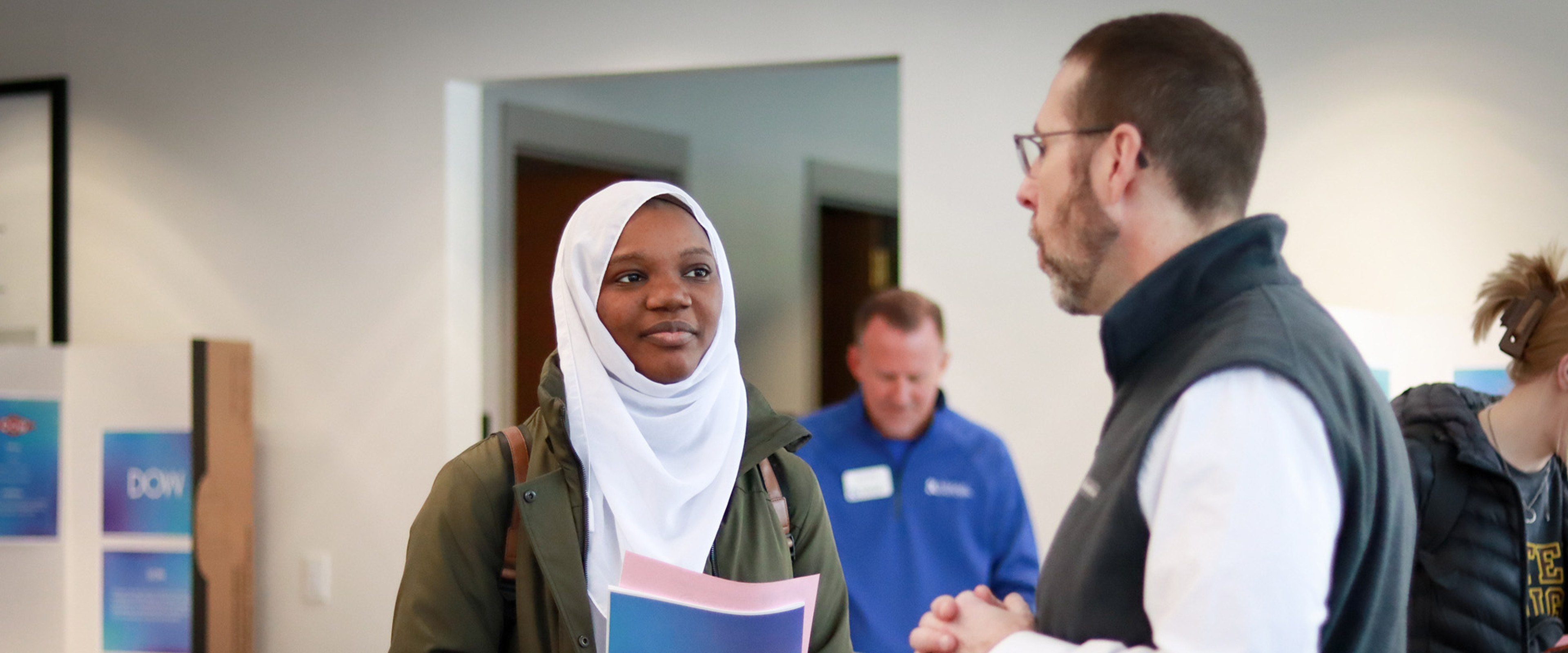 A student is talking with a job recruiter at a Business Externship Program networking event.