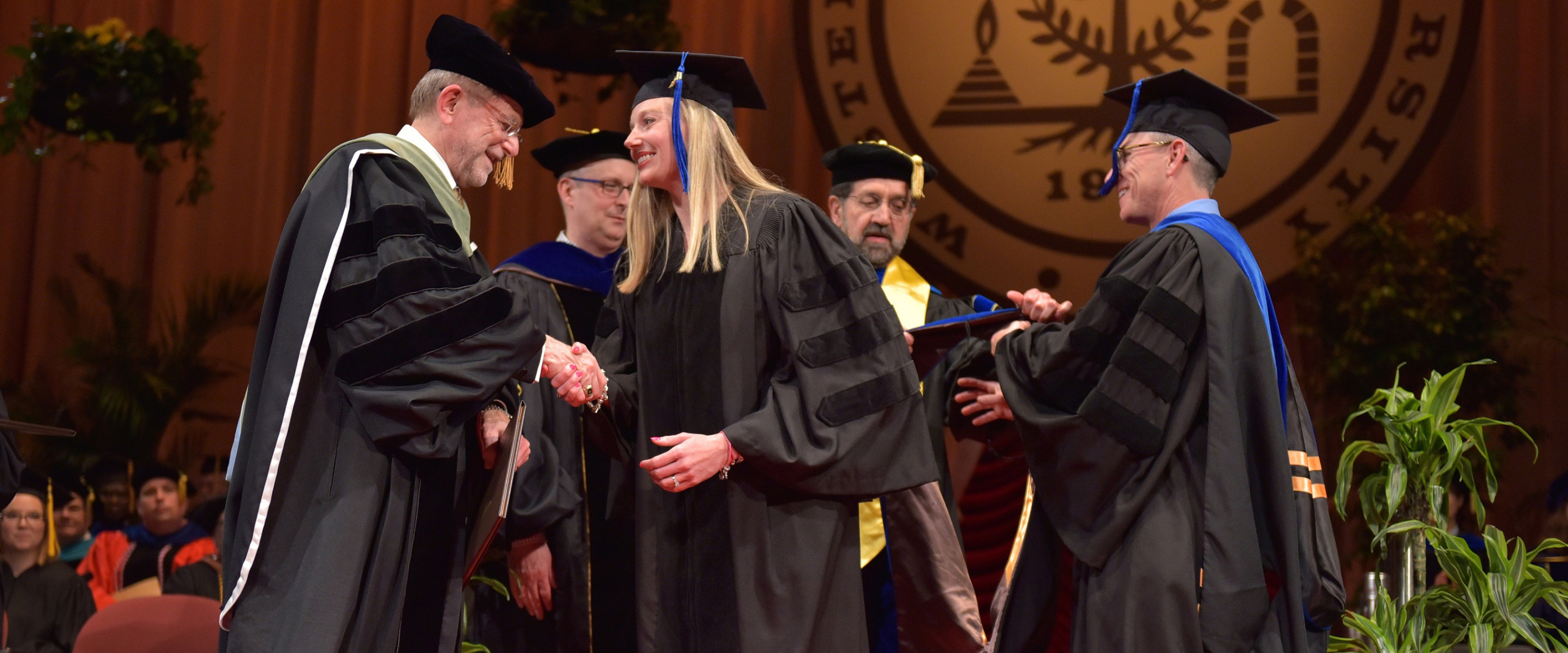 Lindsay Jo Jeffers shakes President Dunn's hand on graduation stage