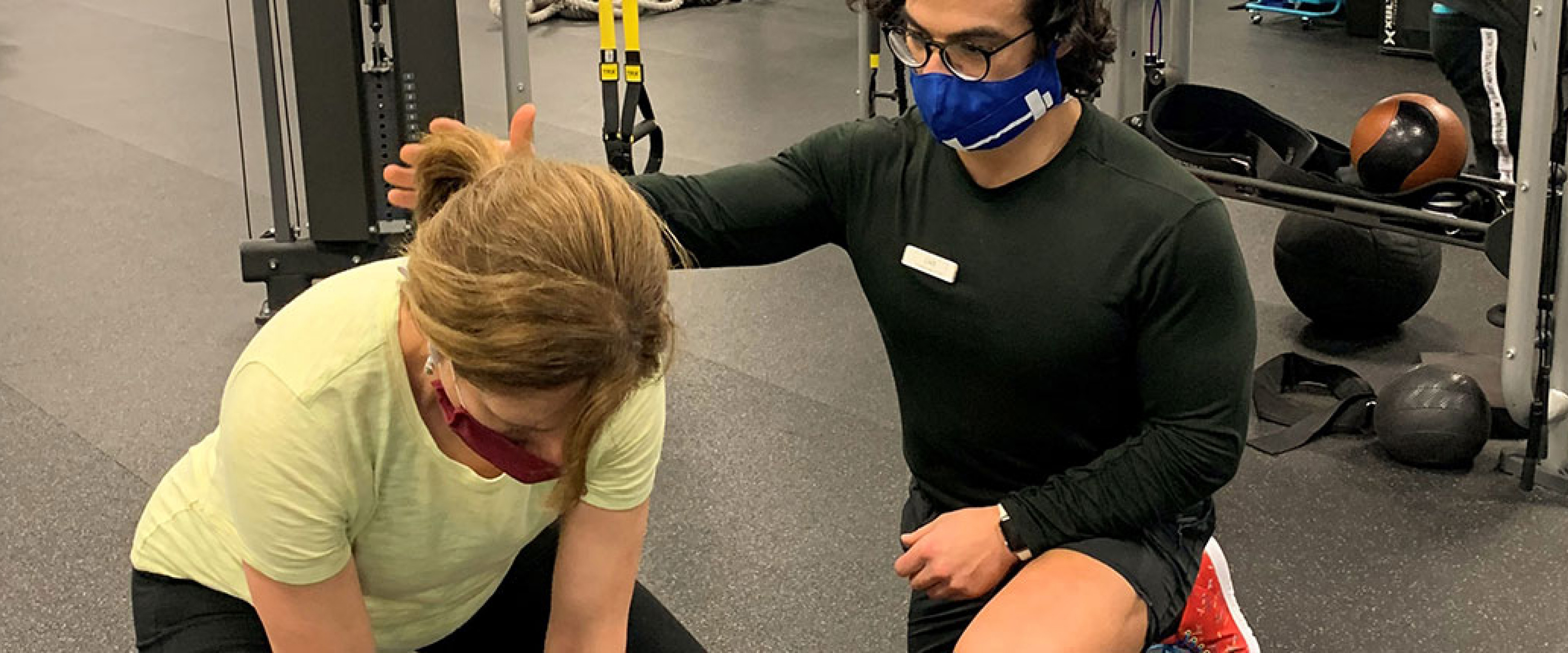 Personal trainer assisting a female client