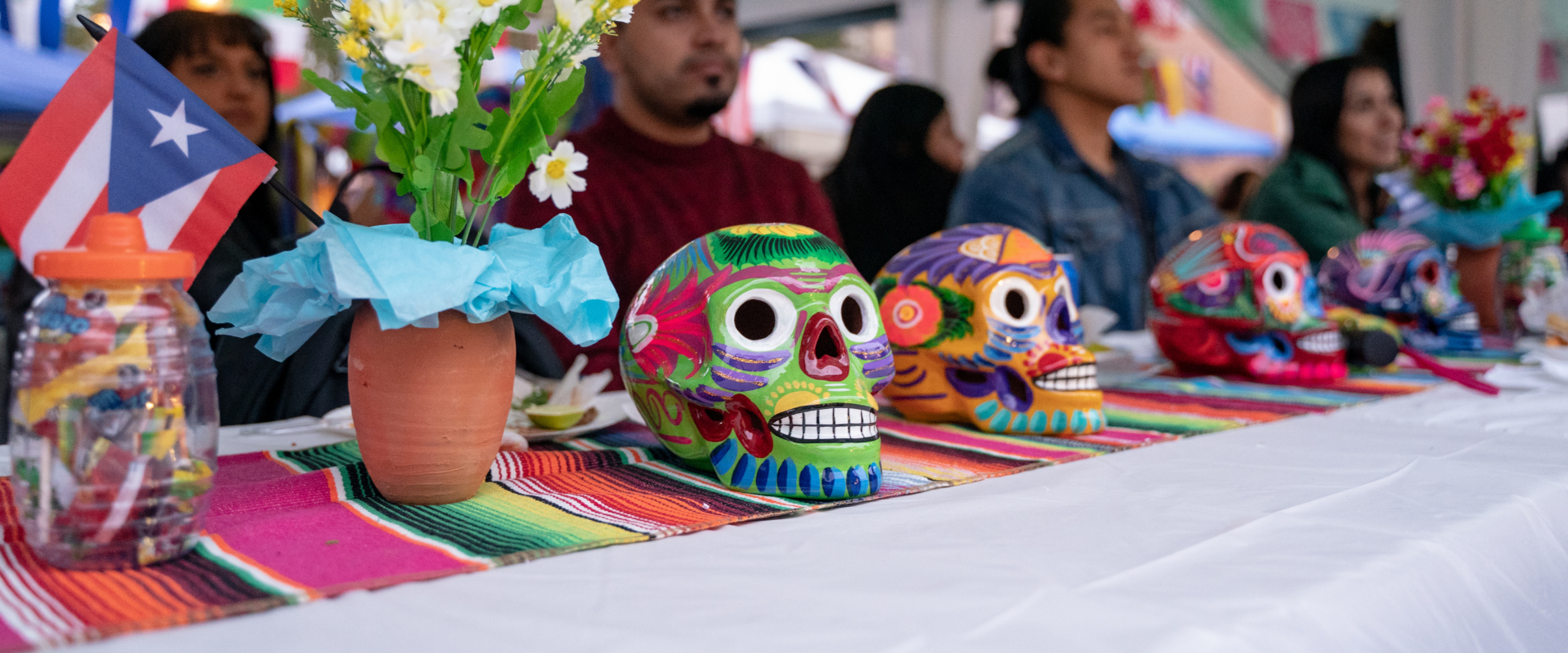 A row of four colorful Day of the Dead sugar skulls.
