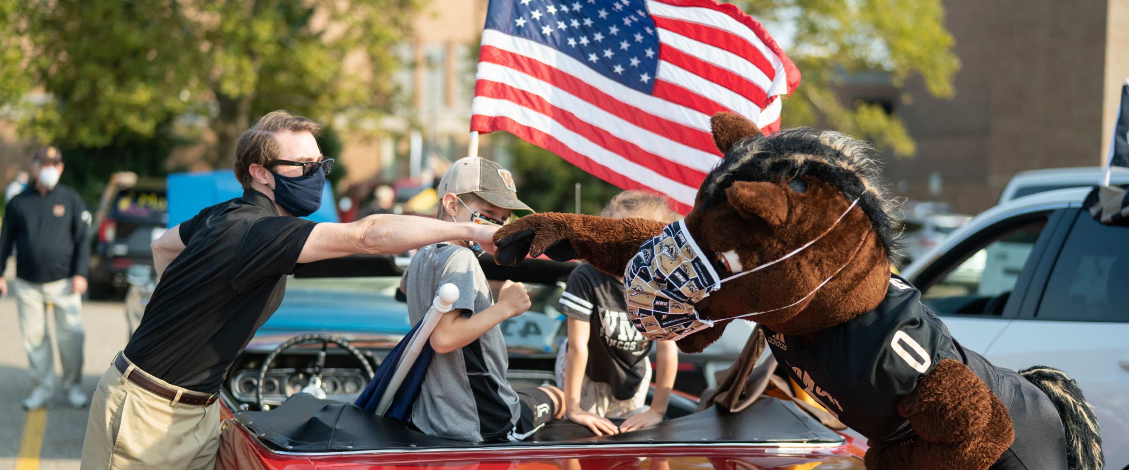 Buster Bronco bumps the fist of a man during the parade.