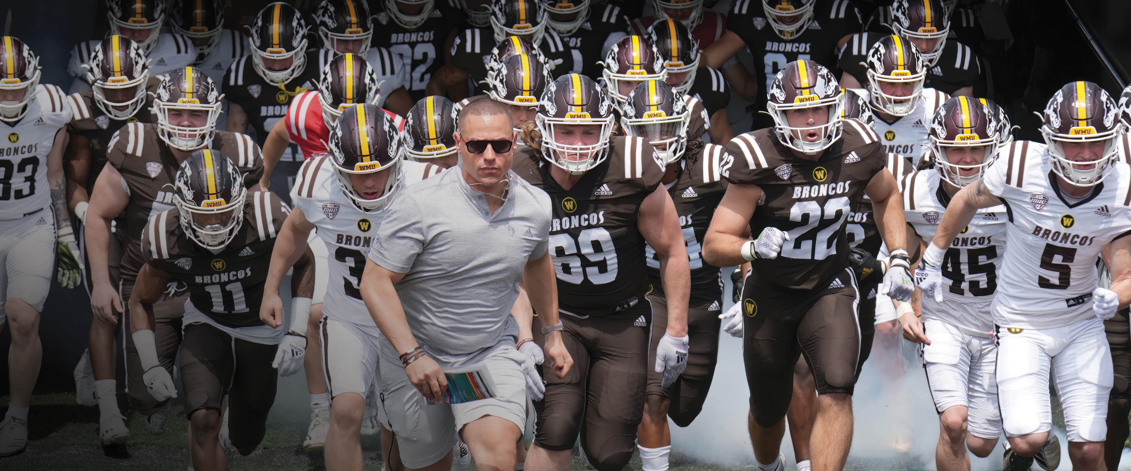 WMU's football team runs out onto the field behind new coach Lance Taylor.