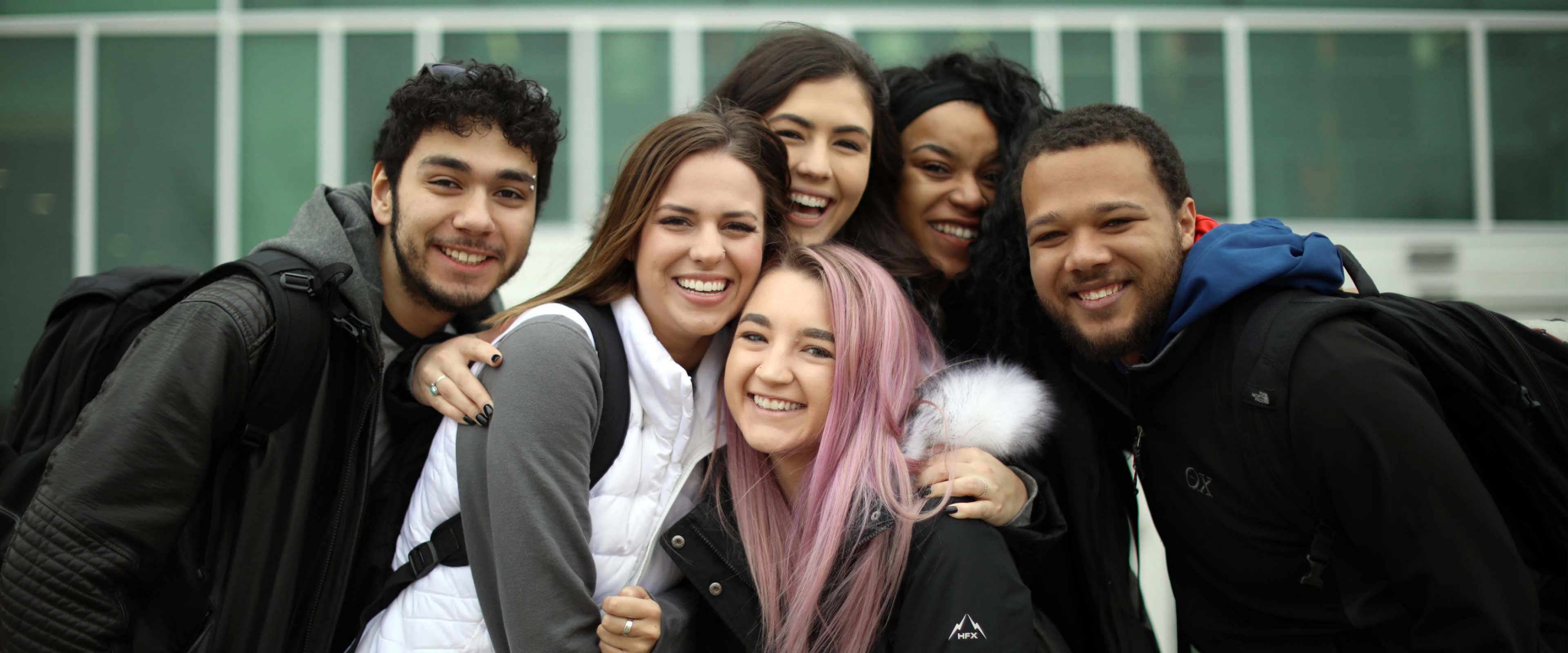 WMU students smile and pose outdoors on campus