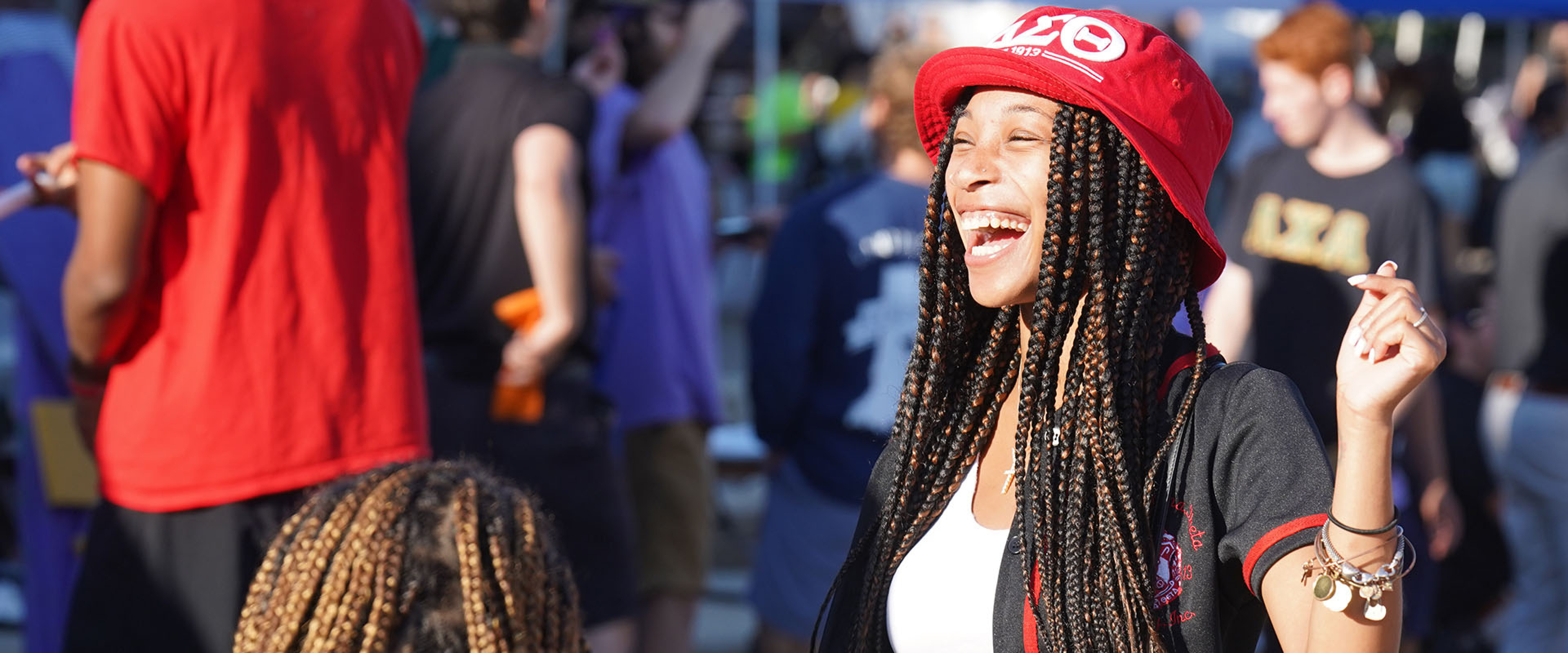 A WMU student laughing amidst a crowd