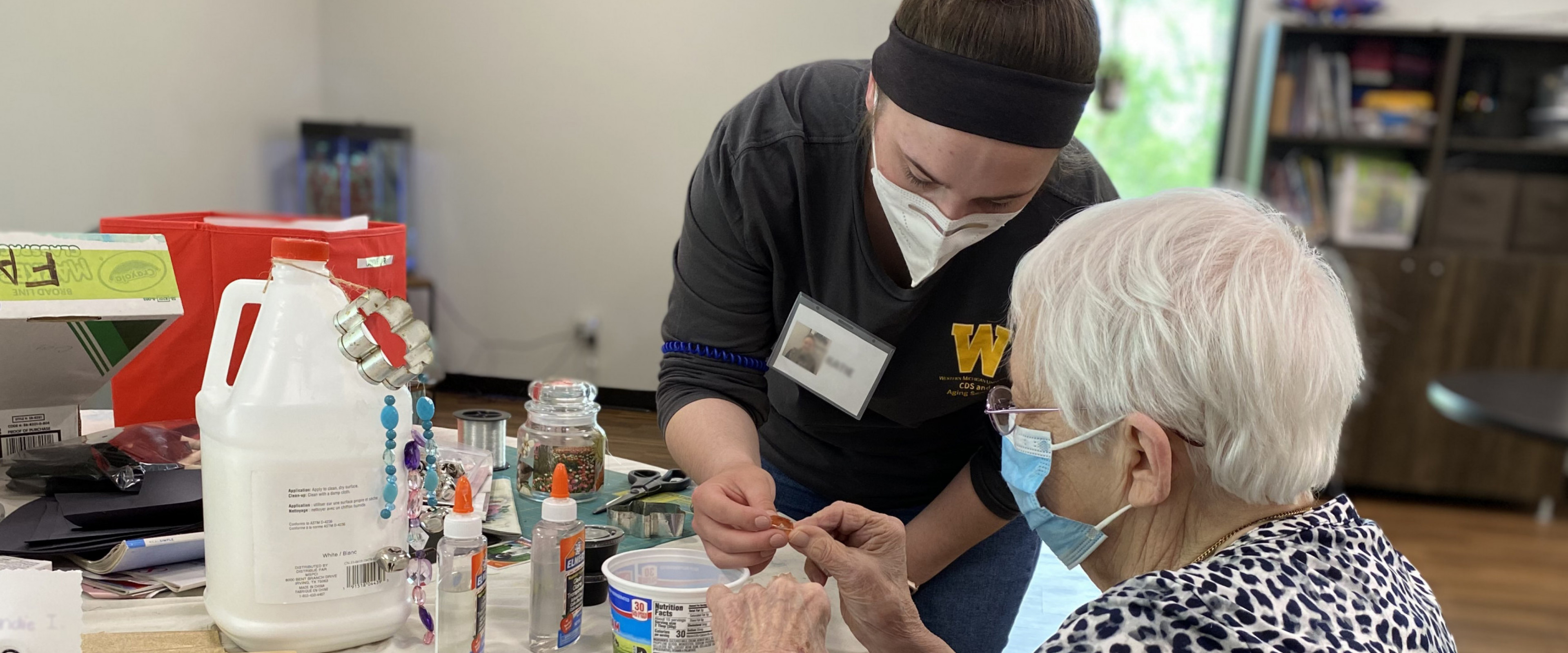 Staff member works on a craft with an older woman