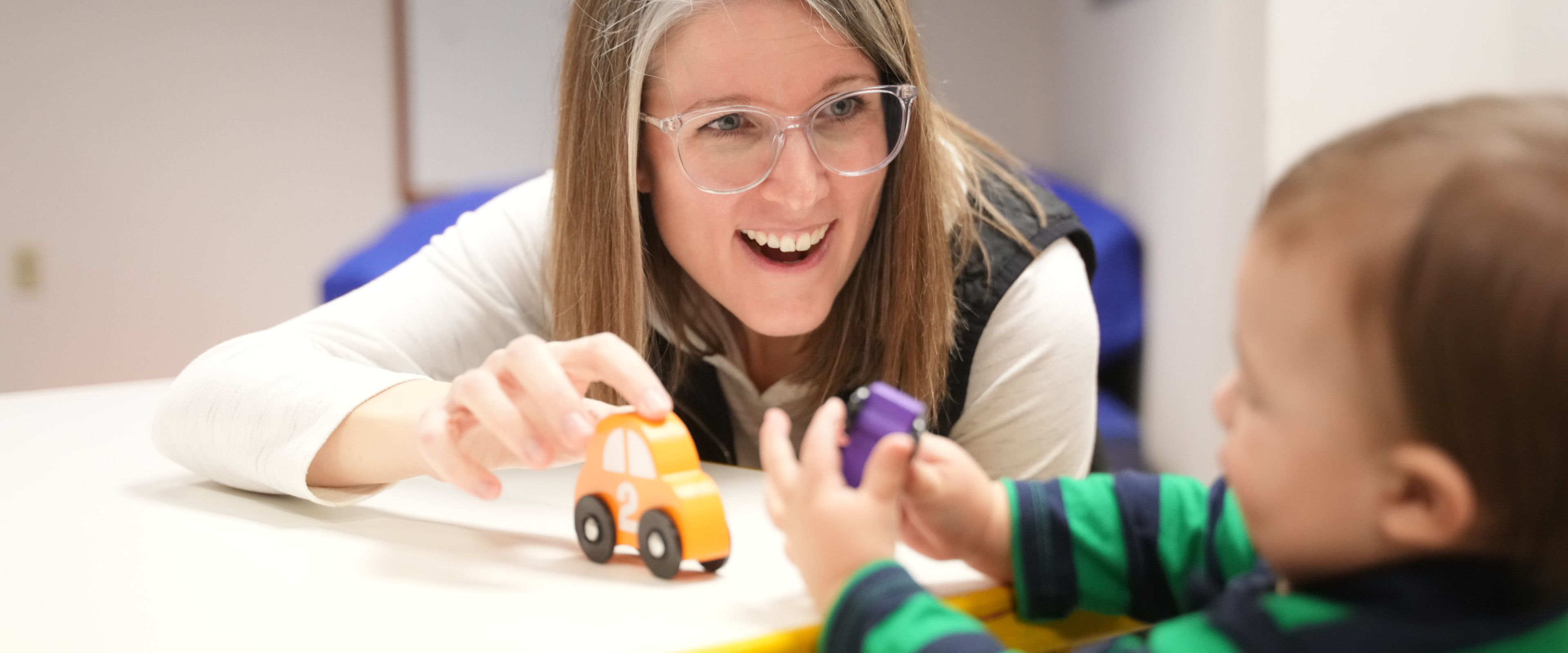 Student clinician playing cars with infant