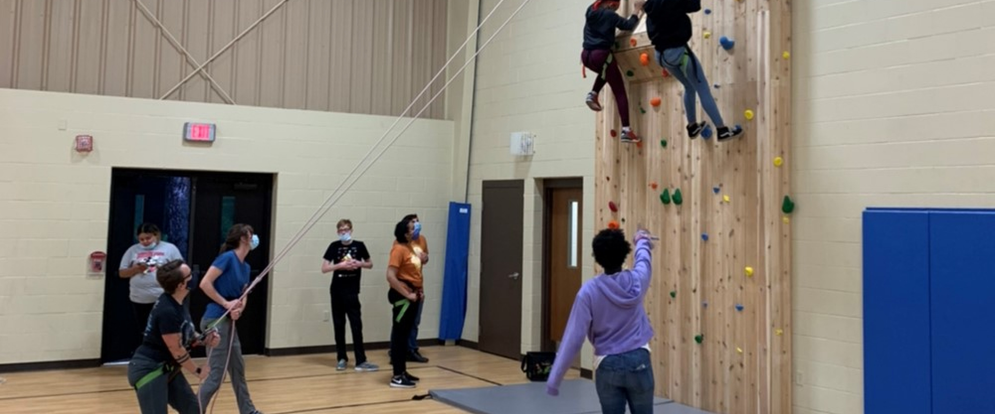 students climbing an indoor wall