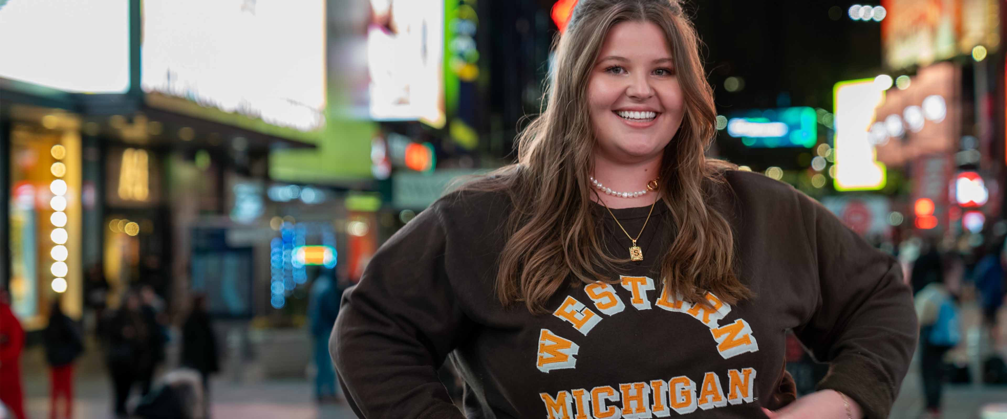 Samantha Morehead posing in her WMU shirt in Times Square.