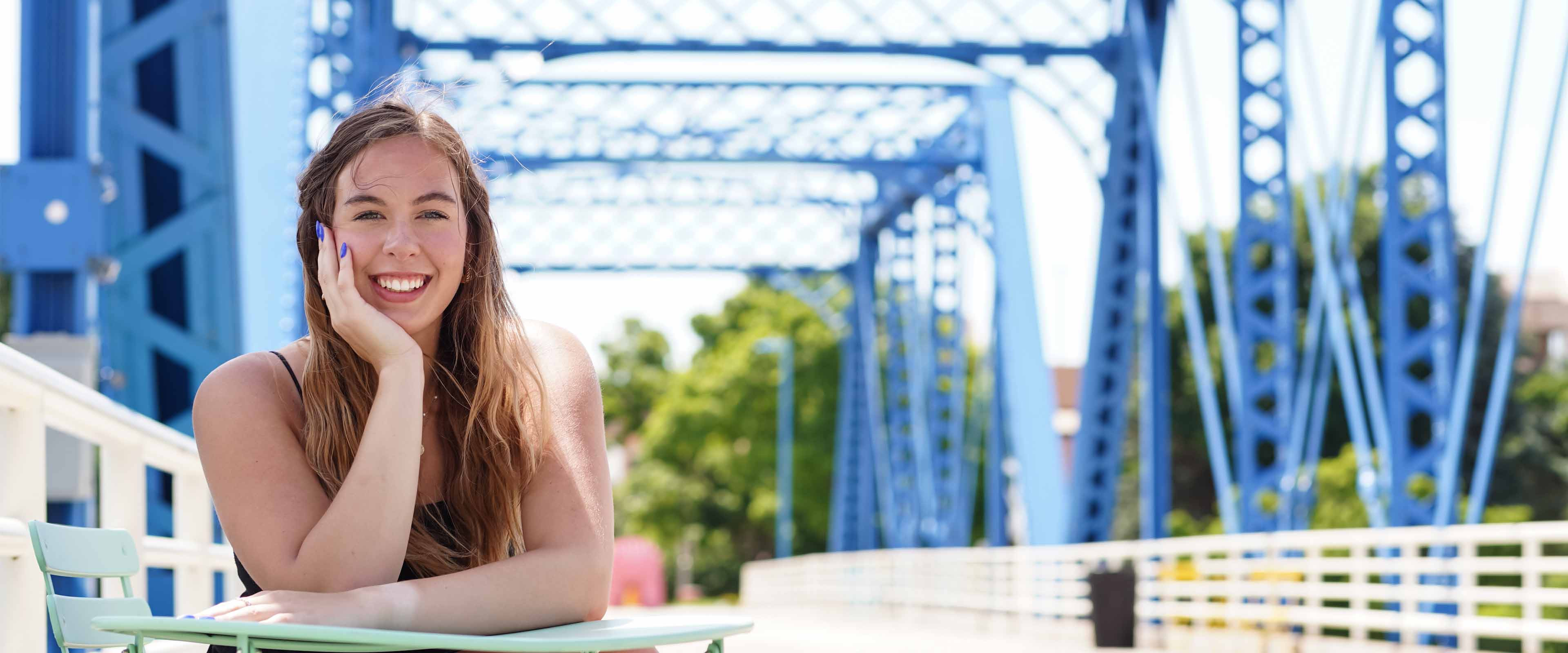 Katherine Jendrasiak sitting at the Blue Bridge in Grand Rapids.