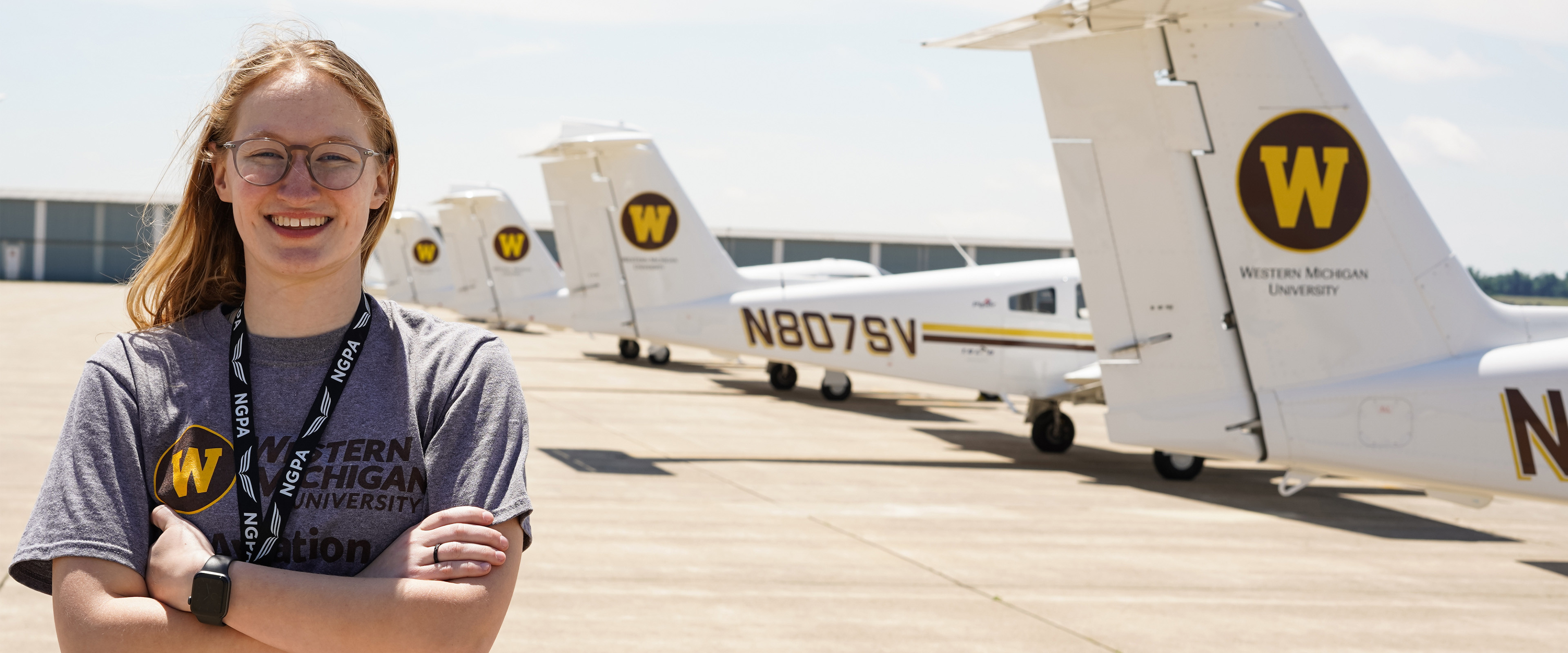 A pilot student standing in front of the WMU planes.