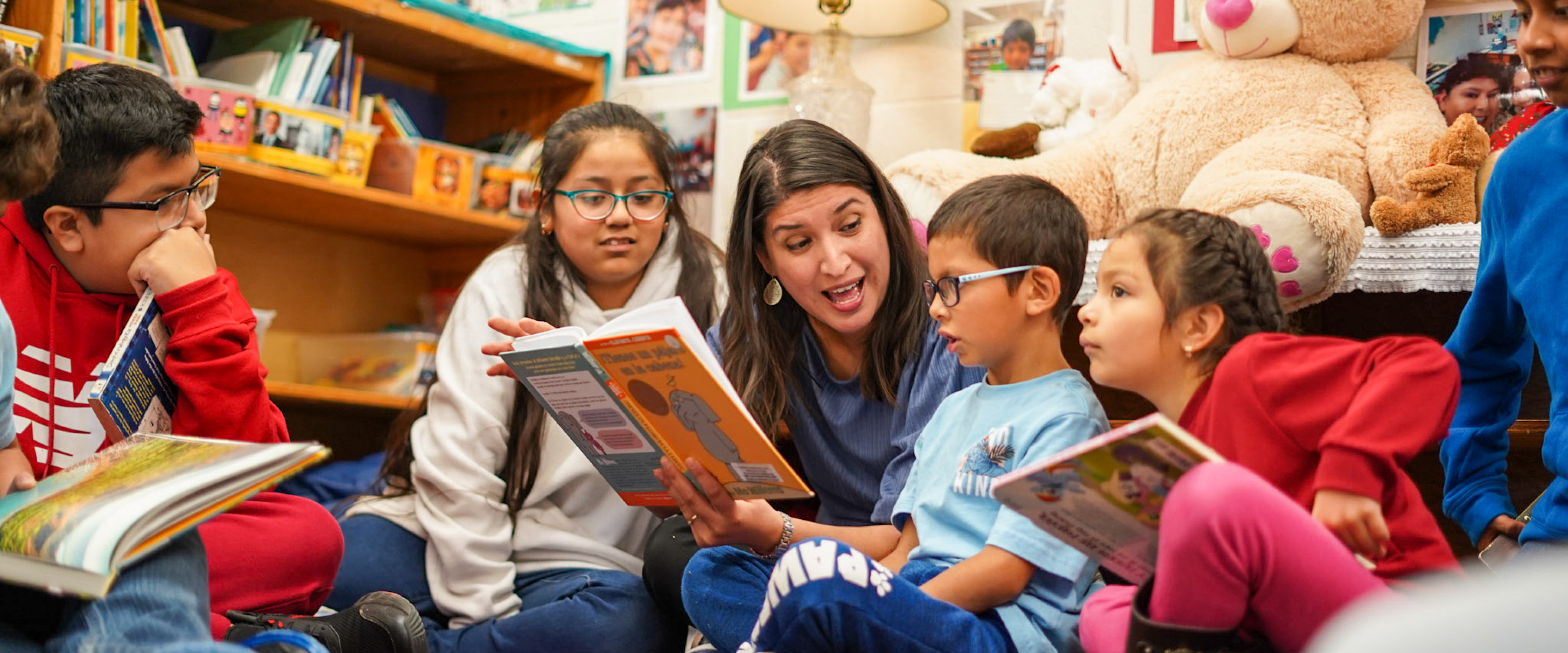 A Western alumna reading to students in her classroom.