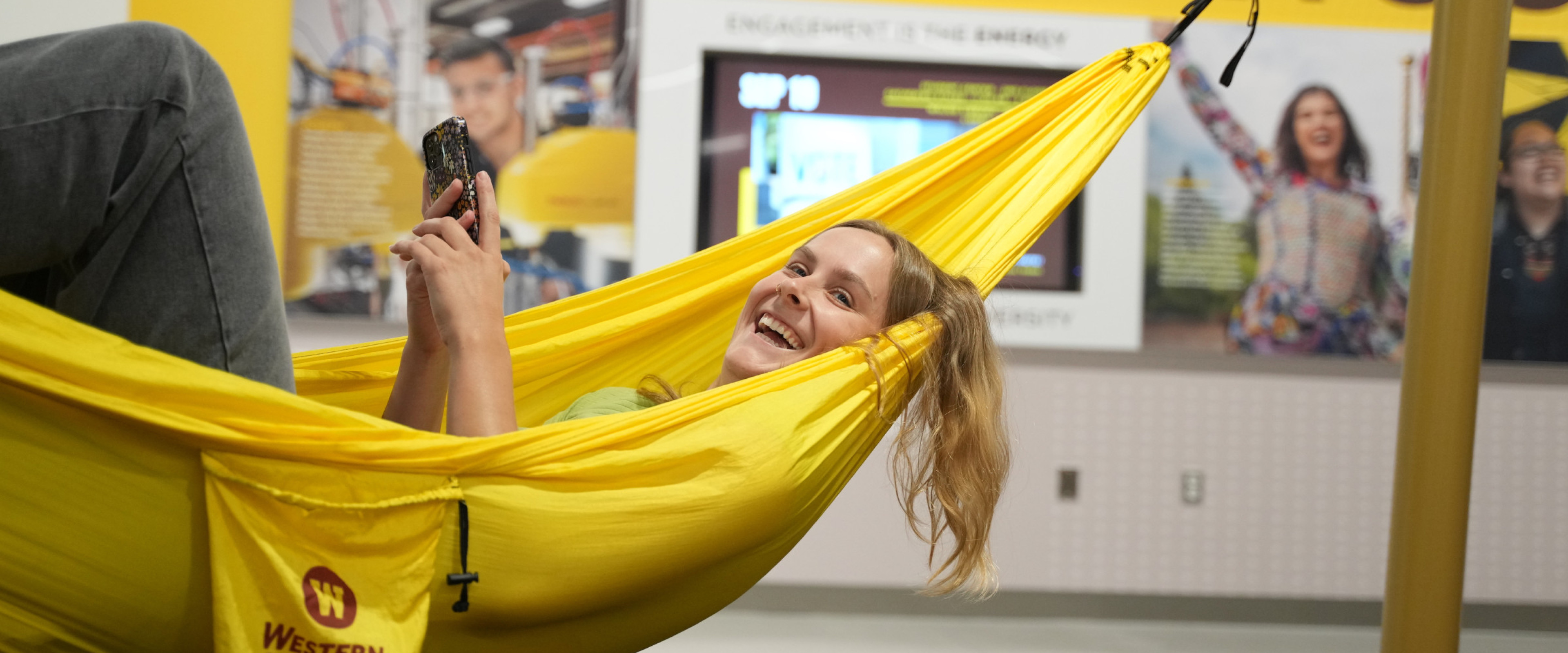 A student hammocking in the new student center.