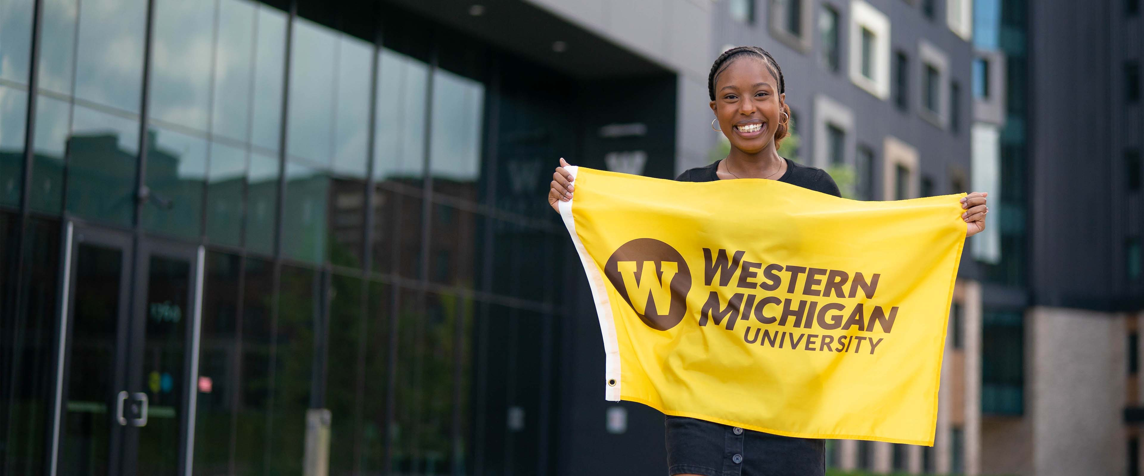 A student holding a Western Michigan University flag.