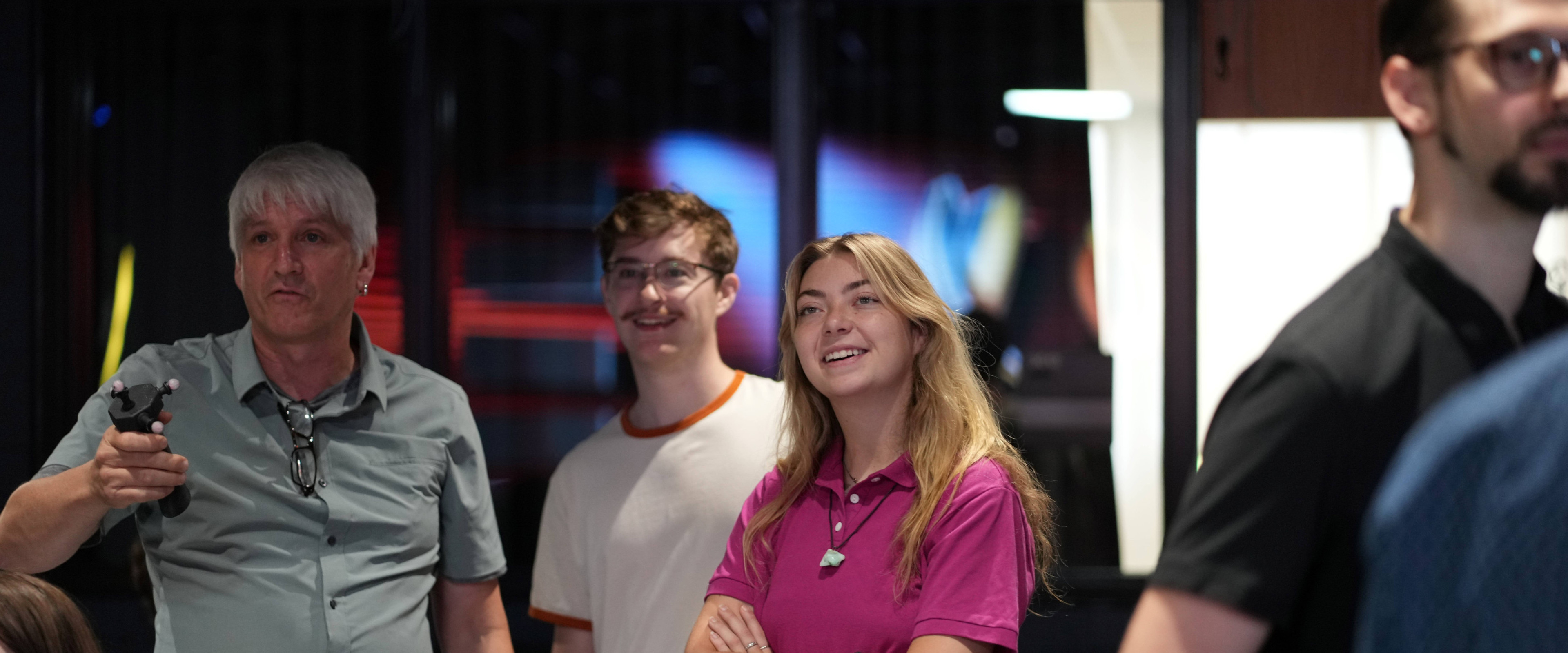 Students smile as they engage with the interactive features of the LED wall.