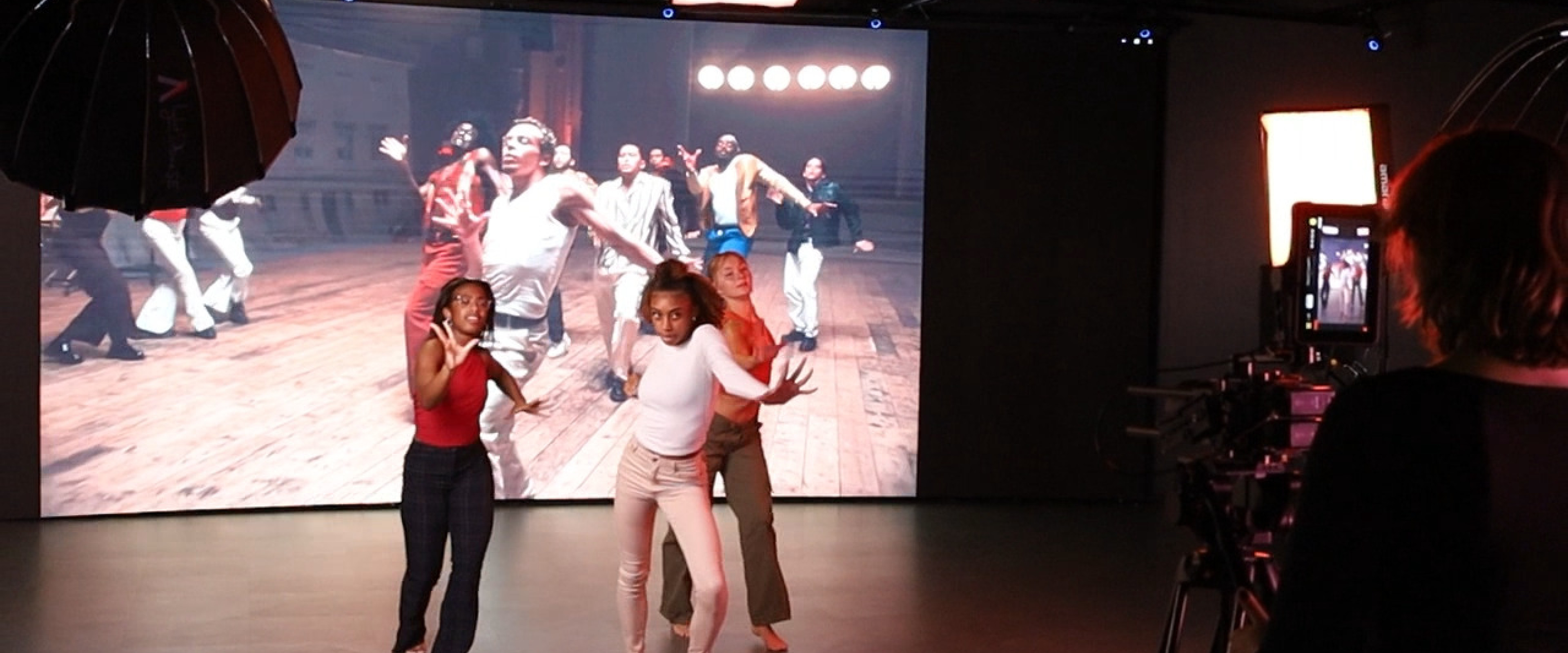 Dancers filmed performing alongside music video in front of LED wall using Red Komodo camera and lighting instruments.