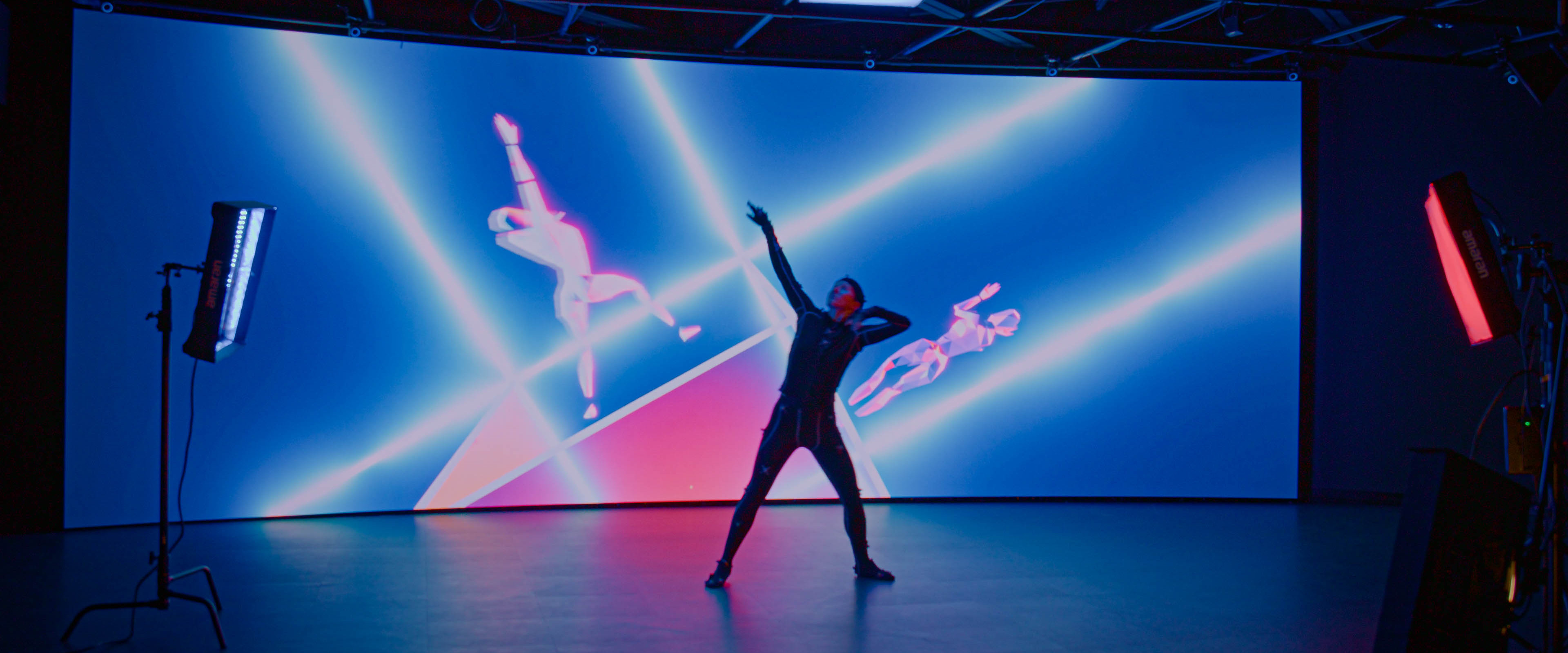 Dancer performing in motion capture with corresponding avatars on the LED wall.