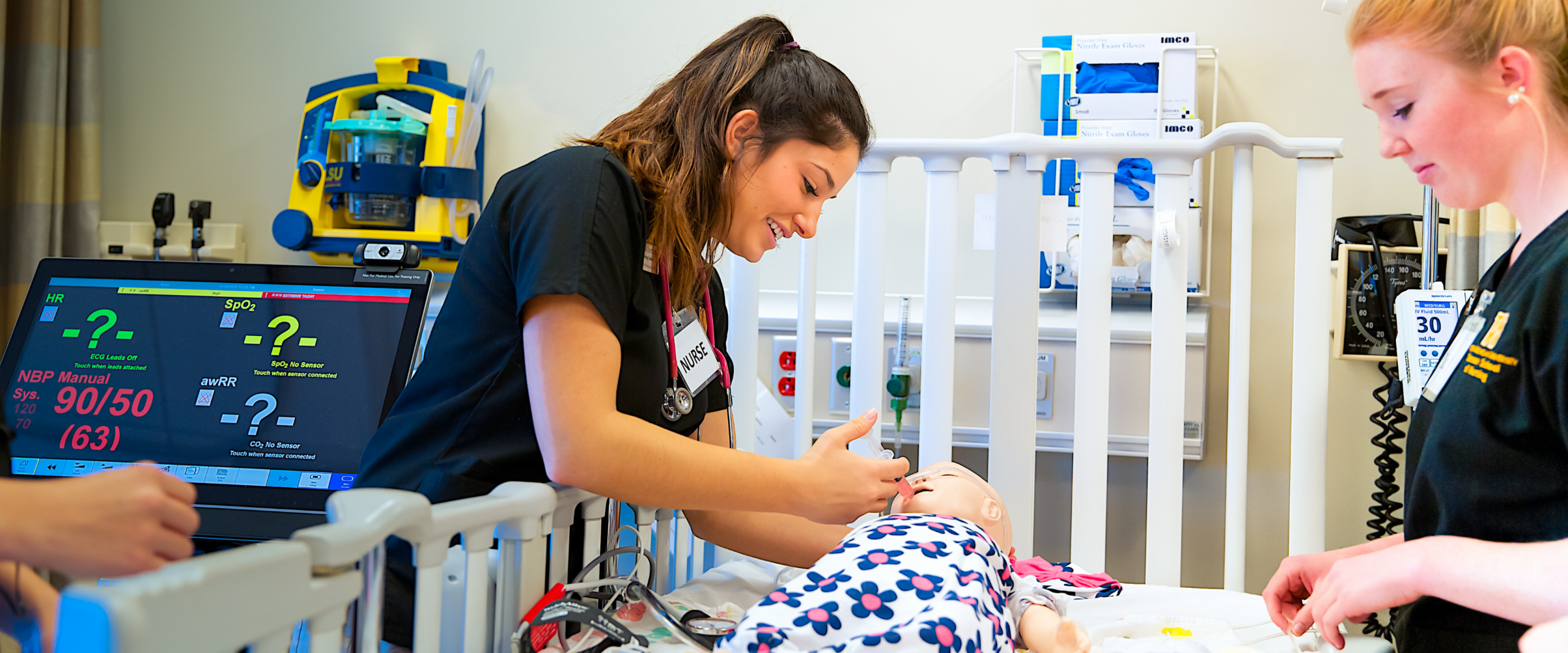 Nursing students working with baby simulator 