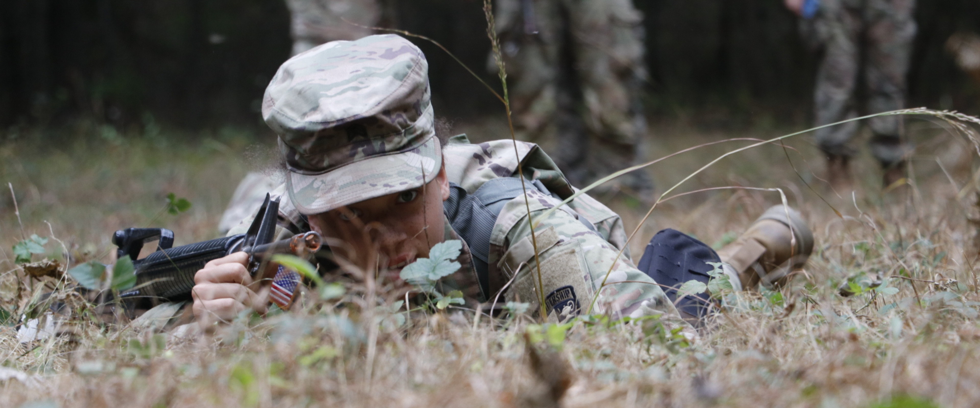 Female cadet low crawling during field training exercise